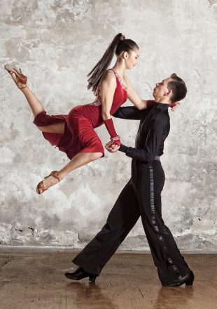 Dance beautiful couple dancing ballroom dancing on wall background. Toned image